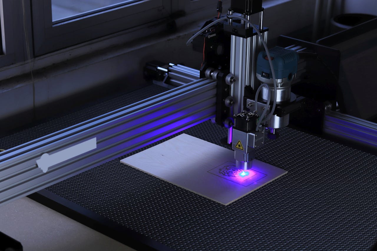 Close-up of a CNC laser engraving machine processing a wooden piece.